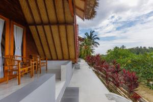 a porch of a house with chairs and plants at La Rise Penida Cottage in Nusa Penida