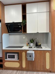 a kitchen with white cabinets and a microwave at Măng Homestay in Kim Quan