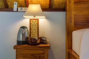 a lamp sitting on a table next to a bed at La Rise Penida Cottage in Nusa Penida
