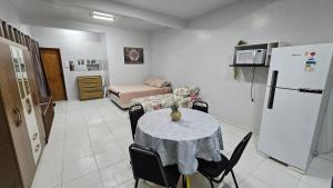 a living room with a table and a refrigerator at Estúdio Completo in Marabá
