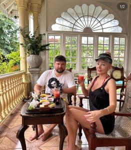 a man and a woman sitting at a table with drinks at Villa Sethoskai -100m to Beach in Ambalangoda