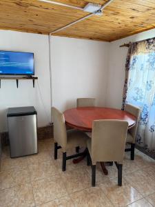 a dining room with a table and chairs and a tv at Complejo Indanna in San Rafael