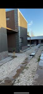 a building with a gravel yard in front of a building at Complejo Indanna in San Rafael +3 photos