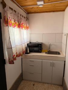 a small kitchen with a sink and a microwave at Complejo Indanna in San Rafael