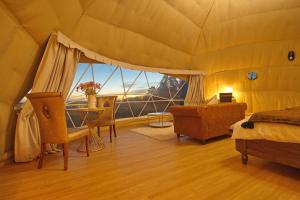 a bedroom with a bed and a table and a large window at One life Glamping Tent in Rawson