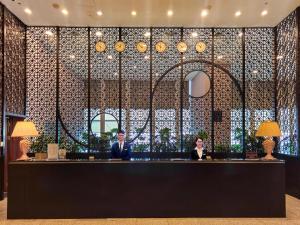two people sitting at a bar in a lobby at Calidas Landmark 72 Royal Residence Hanoi in Hanoi +39 photos