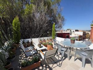a patio with a table and chairs and potted plants at NIDO Hotel in San Miguel de Allende