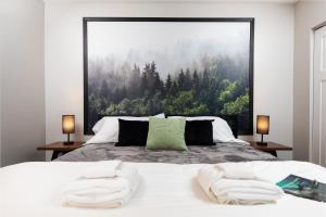 a bedroom with a large picture of a forest at Maple Street Retreat in Bellaire