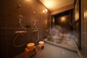 a bathroom with a shower and a toilet and a tub at 湯宿灯火 in Beppu