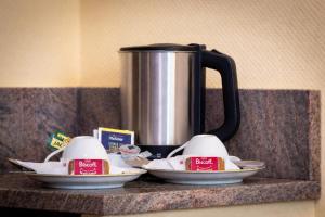 a coffee pot on a counter with two plates of food at Gasper Business & Garden Hotel in Raunheim +16 photos