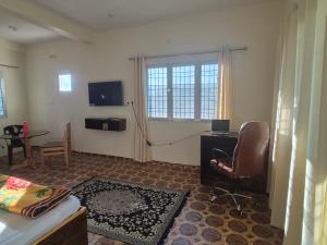 a room with a bed and a desk and a television at Roaming Rovers - Pet-Friendly & Peaceful Homestay in Almora in Almora
