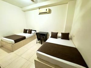 a room with two beds and a table in it at Hotel Buenavista Valledupar in Valledupar +61 photos