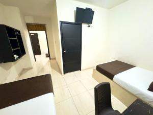 a hotel room with two beds and a television at Hotel Buenavista Valledupar in Valledupar