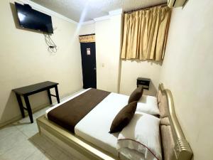 a bedroom with a bed and a tv on the wall at Hotel Buenavista Valledupar in Valledupar