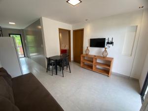 a living room with a television and a table and chairs at Villa Visgo Itacaré in Itacaré