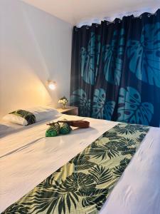 a bedroom with two beds and a curtain at Airport Pamatai Studio in Faaa