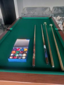 a green pool table with four cuesticks on it at ARHH castle in Ginigathena +3 photos