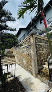 a stone wall with stairs and a bench in front of a building at ARHH castle in Ginigathena