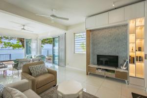 a living room with a large tv and a couch and a table at Amarea Beach Front Appartment or Studio in Richeterre