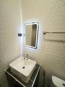 a white bathroom with a sink and a mirror at SB The Moon Night Betong in Betong