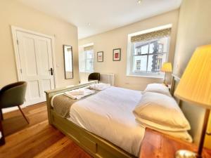 a bedroom with a bed and a chair and a window at RIVERBANC in Llangollen