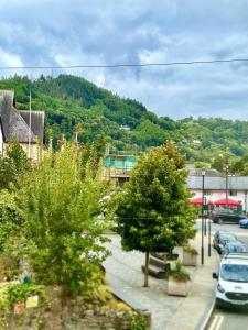 a town with cars parked in a parking lot at RIVERBANC in Llangollen