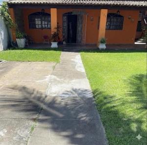 a house with a palm tree in front of it at Refúgio ao mar in Rio das Ostras
