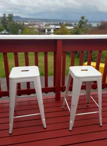 two white stools sitting on a red deck at Steve's Cozy Retreat in Taupo
