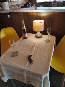 a table with two glasses and a bottle and a lamp at Steve's Cozy Retreat in Taupo +11 photos