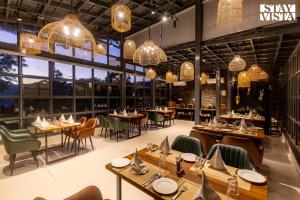 a restaurant with tables and chairs and chandeliers at Sirmour Baag by Vaana - A part of StayVista in Nahna