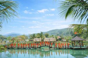 a bridge over a body of water with people in orange uniforms at Đồi Dẻ Eco HomeStay in Bố Trạch +64 photos