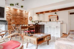 uma sala de estar com uma parede de tijolos e uma mesa em Loft 9 Rue Fermat em Toulouse