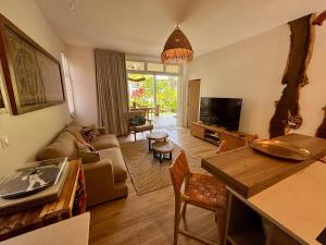 a living room with a couch and a tv at Te mana Dream apartment in Paea