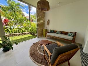 a living room with a couch and a table at Te mana Dream apartment in Paea