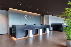 a lobby with a blue counter and two stools at The358 UMI in Fukuoka
