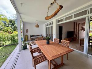 a dining room with a wooden table and chairs at Te mana Dream apartment in Paea