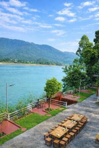 a row of tables and chairs next to a lake at Bon Ben Homestay in Hòa Bình