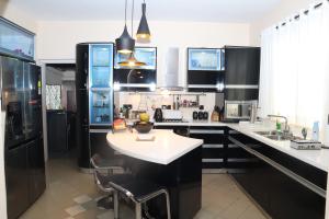 a kitchen with black cabinets and a white counter top at Dehiwala Holiday Villa in Dehiwala