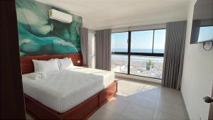 a bedroom with a bed and a large window at Coco Blue a New Beach Resort in La Libertad