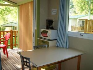 a table and chairs in a kitchen with a balcony at Chalet avec terrasse - 2 pers. - API-1-52-1592 in Saint-Girons