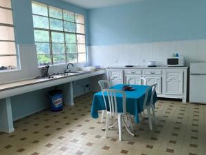 a kitchen with a blue table and white cabinets at Chalet avec terrasse - 2 pers. - API-1-52-1592 in Saint-Girons +9 photos