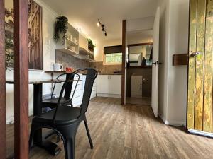 a kitchen with a table and a chair in a room at Guest House in East Devonport in Devonport +4 photos