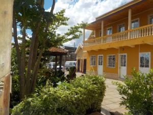 ein gelbes Gebäude mit Balkon an einer Straße in der Unterkunft Rem Hotel in Fianarantsoa