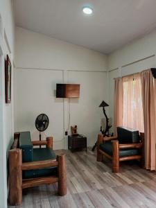 a living room with two chairs and a television at Villa Tucano in Fortuna