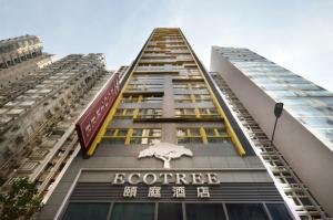 a tall building with a sign on the side of it at Eco Tree Hotel Causeway Bay in Hong Kong