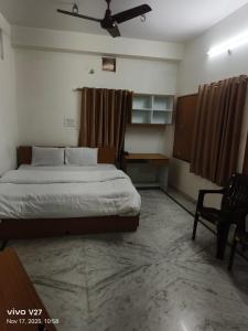 a bedroom with a bed and a table and a fan at Riddhi Guest House in Udaipur +3 photos