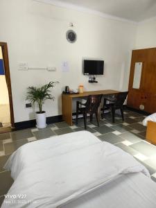 a bedroom with a bed and a table with chairs at Riddhi Guest House in Udaipur