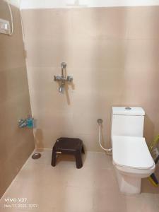 a bathroom with a toilet and a cross on the wall at Riddhi Guest House in Udaipur