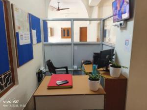 an office cubicle with a desk with a computer and plants at Riddhi Guest House in Udaipur