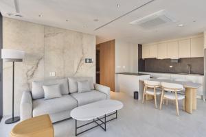 a living room with a couch and a kitchen at Palatium Haeundae by SONO Felice in Busan